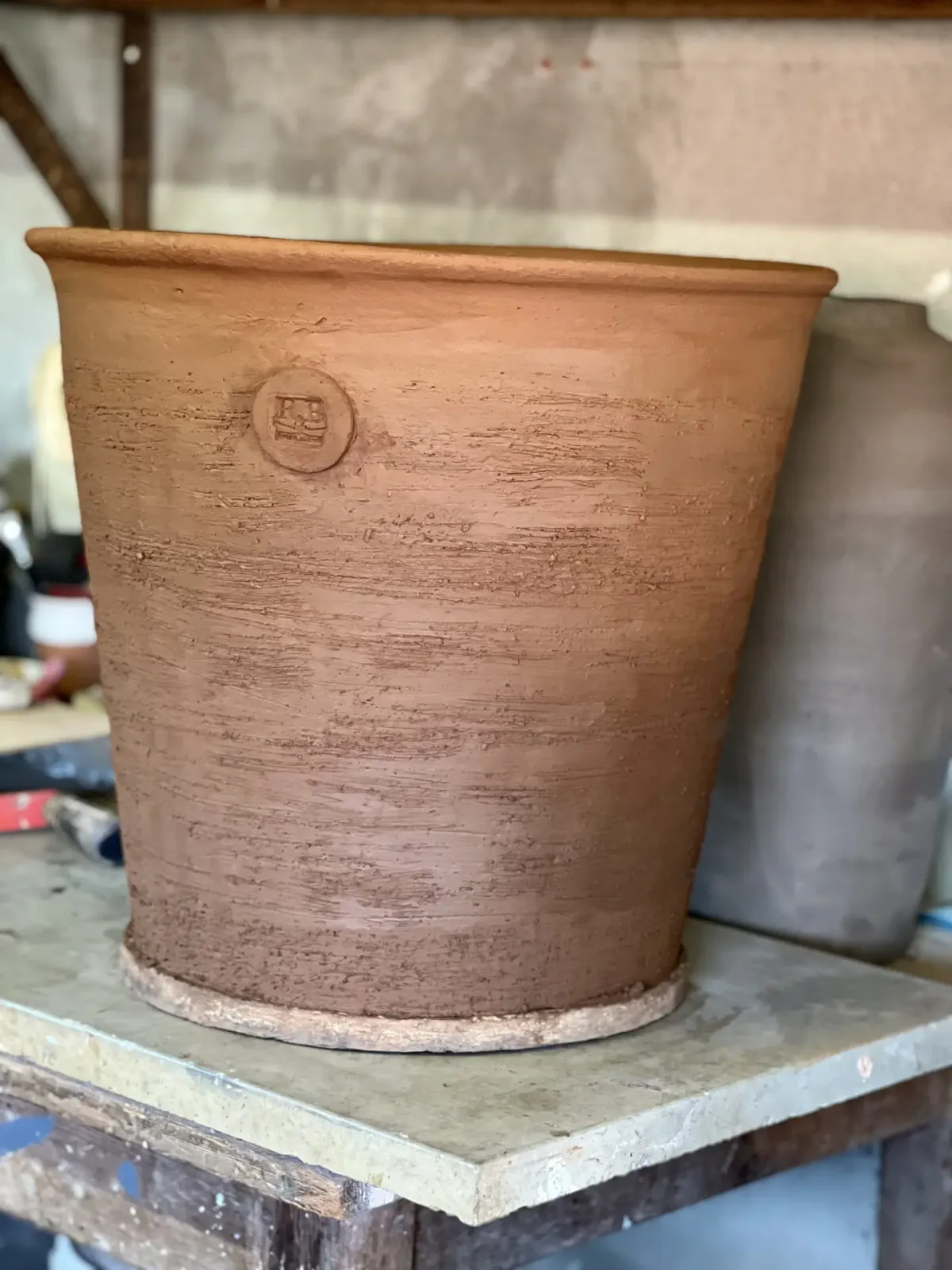 Pot cru en Grès de Noron montrant la texture de la terre et l’estampille R&B avant cuisson